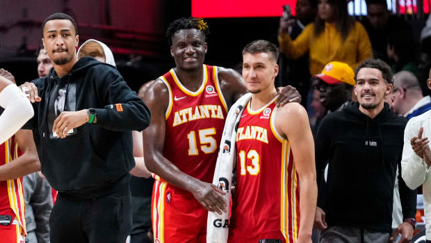 John Collins, Clint Capela, Bogdan Bogdanovic, and Trae Young celebrate on the sideline.